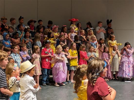 Grades 1-3 performing on stage.